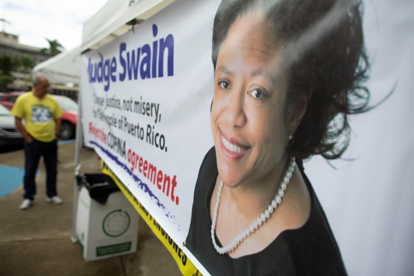 Las protestas ciudadanas continuaron ayer, durante el segundo día de la vista de confirmación del plan de ajuste de Cofina, a cargo de la jueza Laura Taylor Swain, cuya imagen aparece en el cartel.