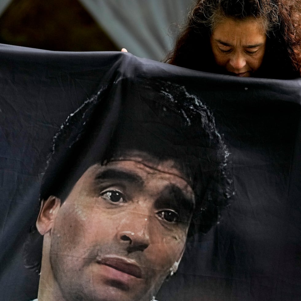 Una fanática de la leyenda del fútbol Diego Maradona sostiene su imagen en las afueras de la corte donde los integrantes del equipo médico que trataron al exfutbolista son juzgados por homicidio en San Isidro, en las afueras de Buenos Aires, Argentina.