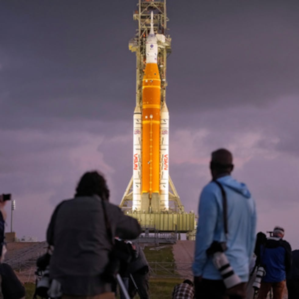 Fotógrafos instalan cámaras remotas cerca del cohete lunar Artermis II de la NASA en la plataforma de lanzamiento 39-B justo antes del amanecer en el Centro Espacial Kennedy el martes.