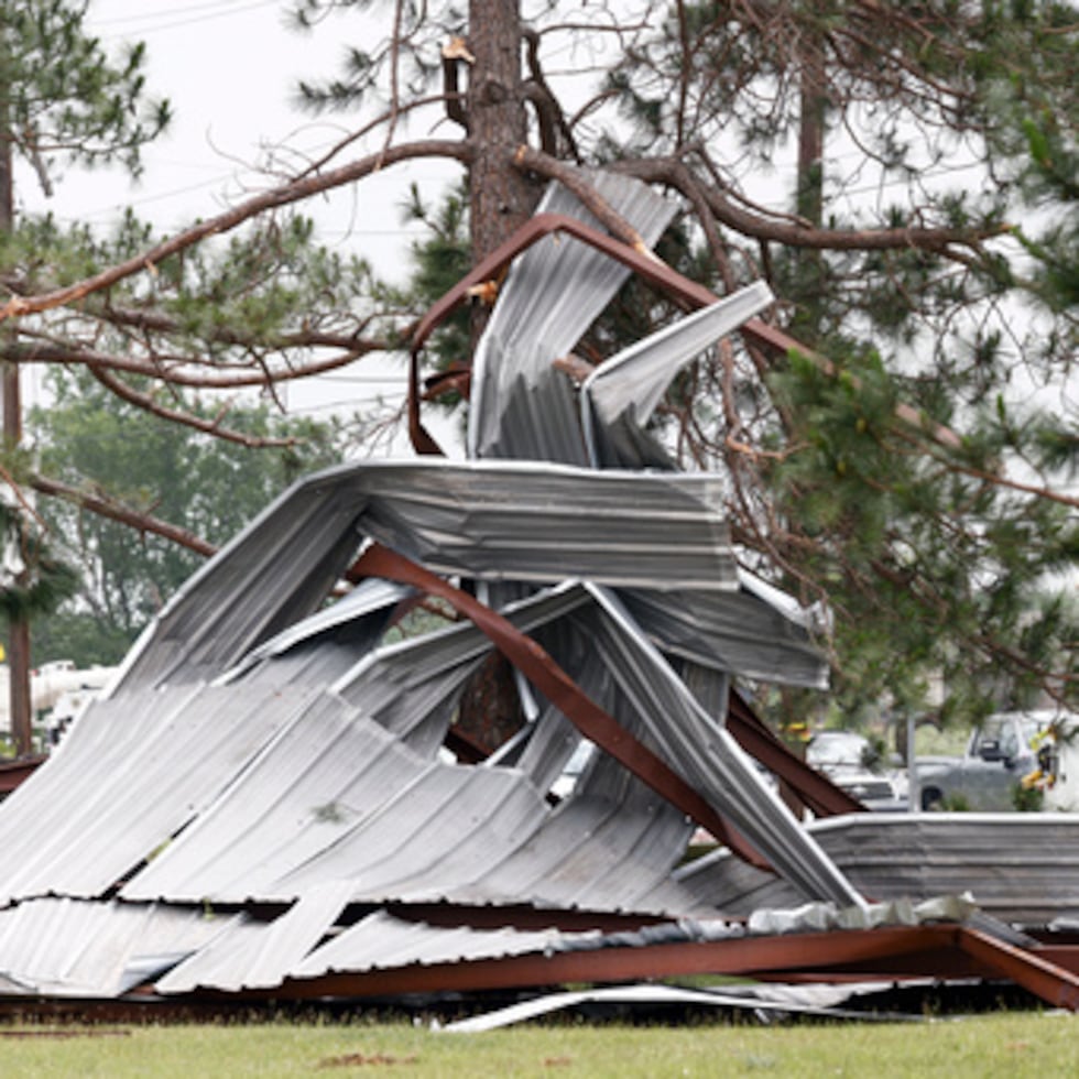 Un edificio de comida descansa retorcido en un árbol tras un posible tornado, el domingo.
