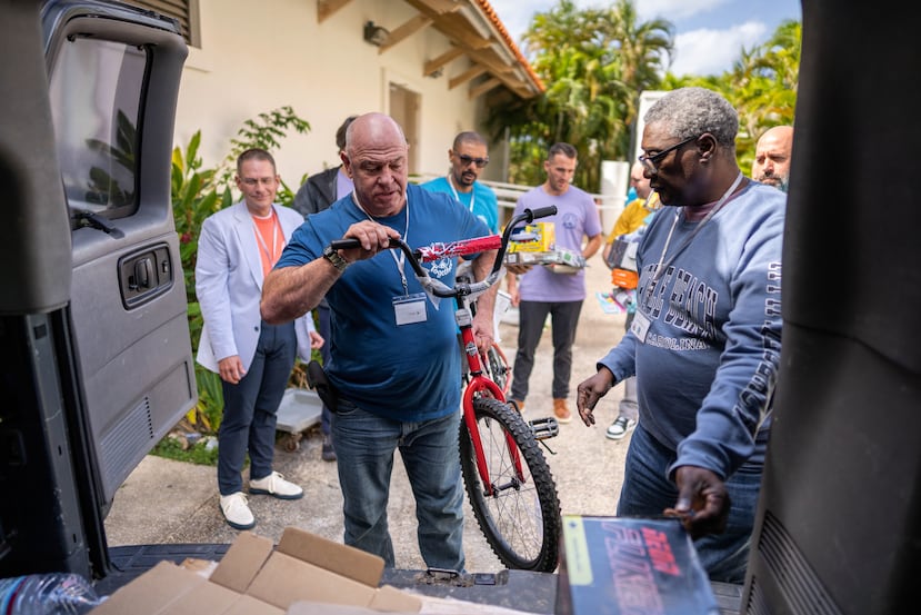 Empleados de Spectrum Brands recogiendo los regalos y colocándolos en la van. Esta llevara los regalos al warehouse de Fort Buchanan de Toys for Tots, donde entonces repartirán los regalos a familias entre diciembre y enero para Navidades y Reyes.