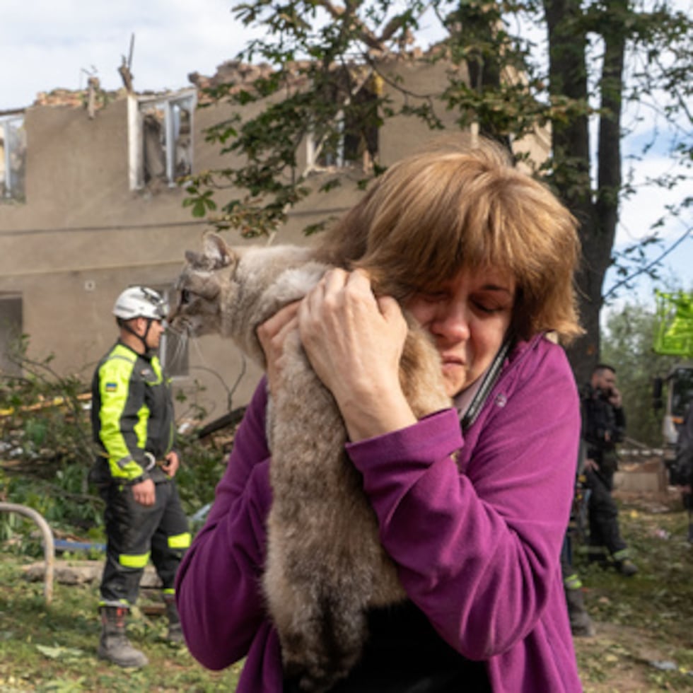 Una mujer sostiene a su gato tras haberlo encontrado durante las labores de búsqueda y rescate en el edificio residencial dañado a raíz del ataque con misiles de Rusia en Járkov.