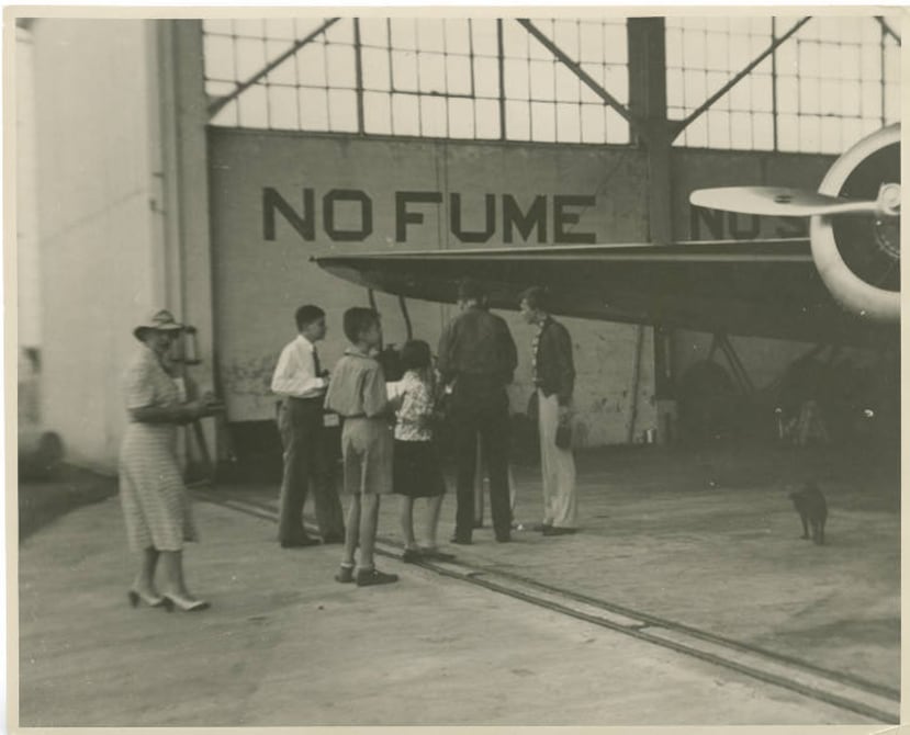 Amelia Earhart y Fred Noonan conversan con jóvenes que piden sus autógrafos en un hangar de Isla Grande, en Puerto Rico, durante su escala en la isla en 1937.