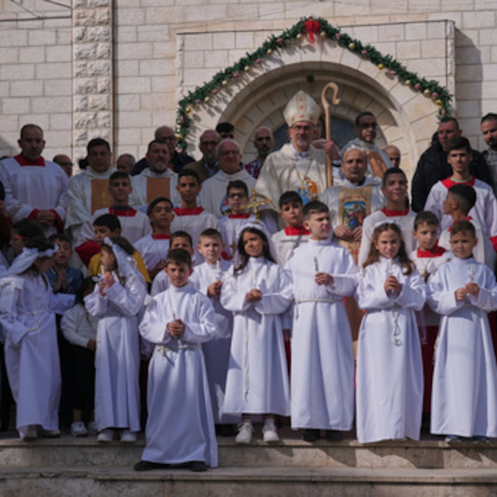 El cardenal Pierbattista Pizzaballa, patriarca latino de Jerusalén, posa para las fotos con feligreses palestinos tras presidir una misa previa a las celebraciones navideñas en la iglesia católica de la Sagrada Familia de la ciudad de Gaza, el domingo 21 de diciembre de 2025.
