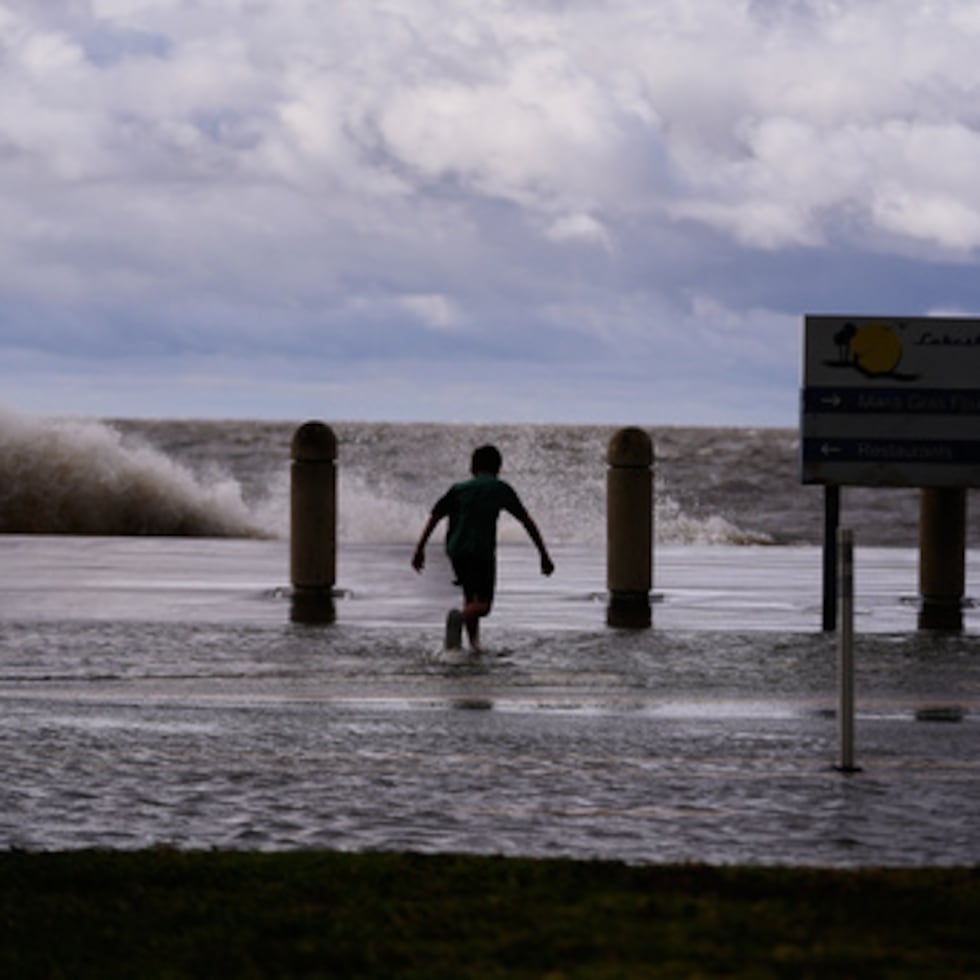 Josiah Carpenter, de 8 años, juega despreocupado en la inundación provocada por la marejada ciclónica en Lakeshore Drive, junto al lago Pontchartrain.