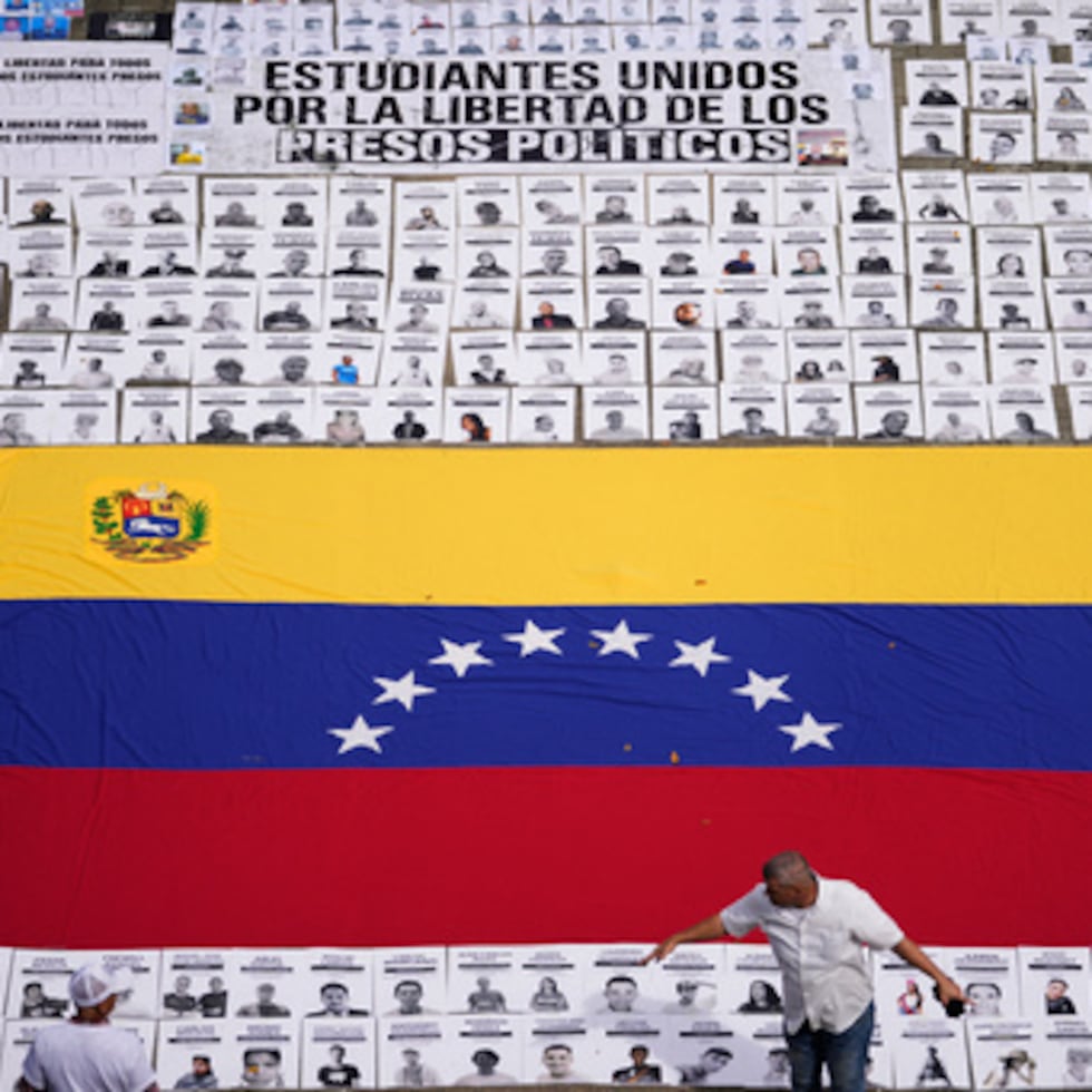 Estudiantes colocan fotos de personas que consideran presos políticos en la Universidad Central de Venezuela en Caracas, Venezuela, martes 13 de enero de 2026. (AP Photo/Matias Delacroix)