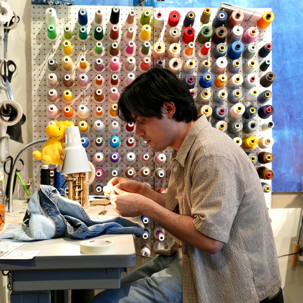 Genaro Ruiz cose ropa durante un taller de reparación de prendas en una tienda de Levi's del centro de San Francisco el 22 de julio de 2026.