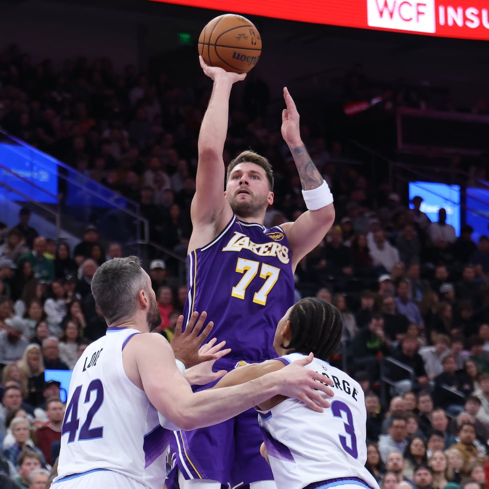 Luka Doncic, de los Lakers, tira por encima de Kevin Love (42) y de Keyonte George (3), del Jazz de Utah.