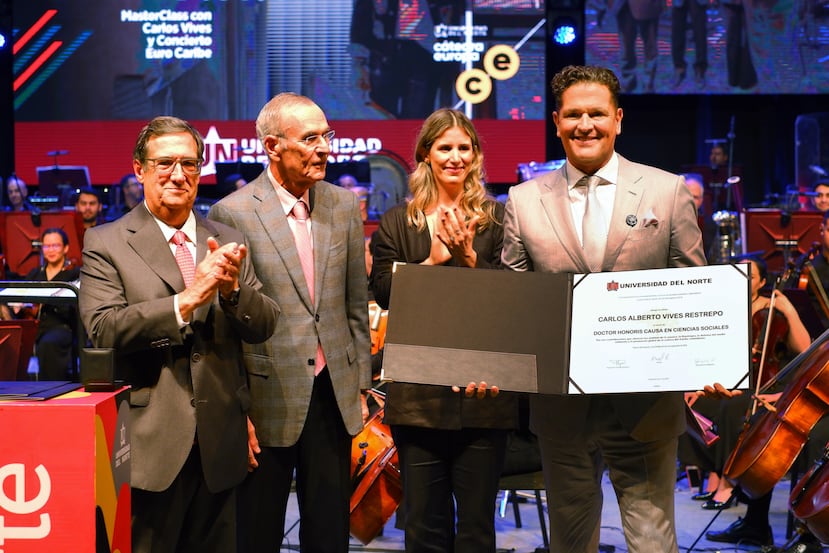 El cantante colombiano Carlos Vives, a la derecha, posa con el diploma del Honoris Causa que le otorgaron, mientras estuvo acompañado por el rector de la Universidad del Norte, Adolfo Meisel (a la izquierda).