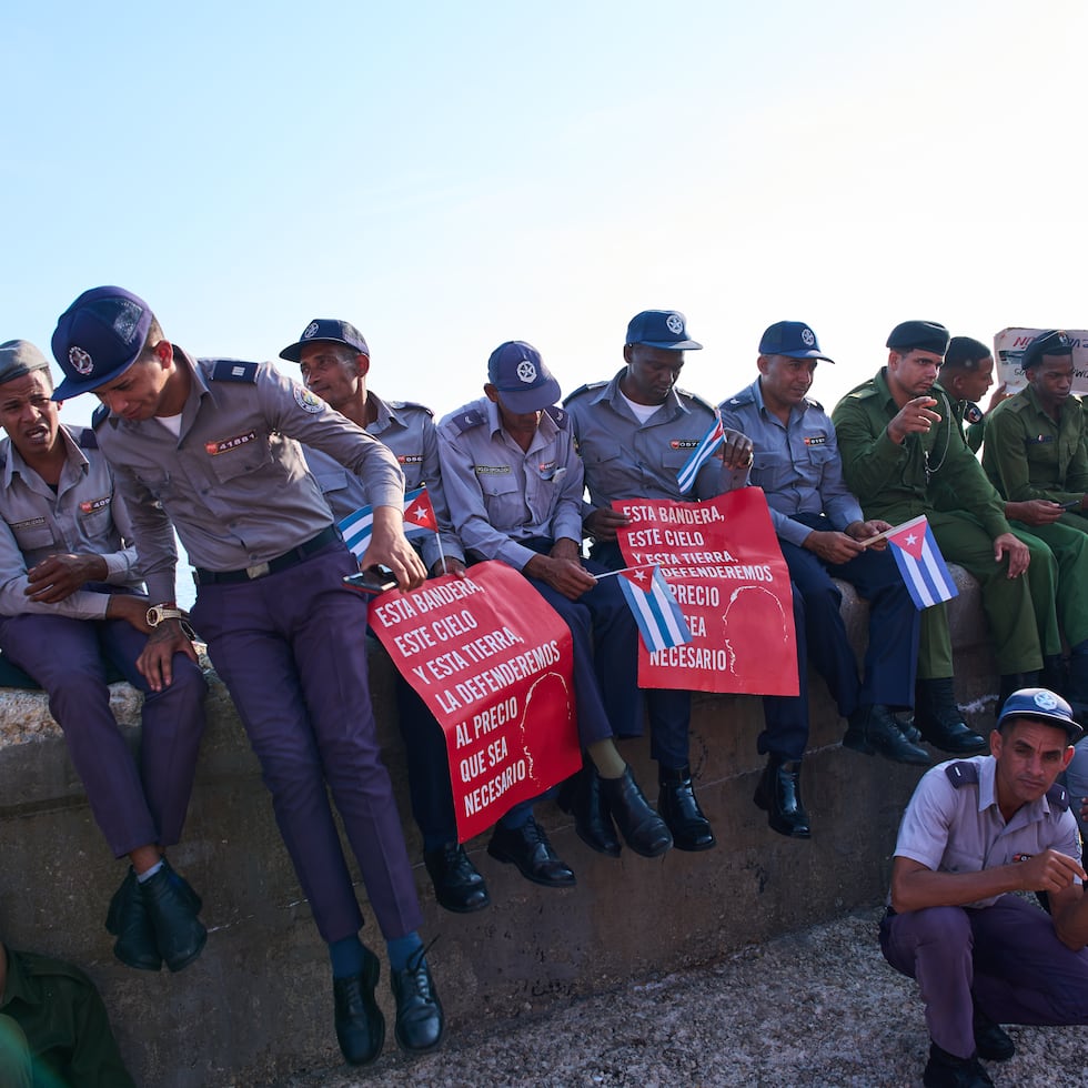 Soldados y policías cubanos durante las concentraciones por el Día Internacional de los Trabajadores en La Habana, con un cartel que lee: “Esta bandera, este cielo y esta tierra, la defenderemos al precio que sea necesario”.