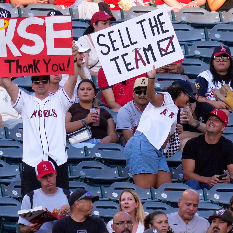 238
Los aficionados muestran pancartas durante la primera entrada de un partido de béisbol entre los Angelinos de Los Ángeles y los Yankees de Nueva York después de que Kroenke Sports and Entertainment llegara a un acuerdo para comprar la propiedad mayoritaria de los Angelinos a Arte Moreno.