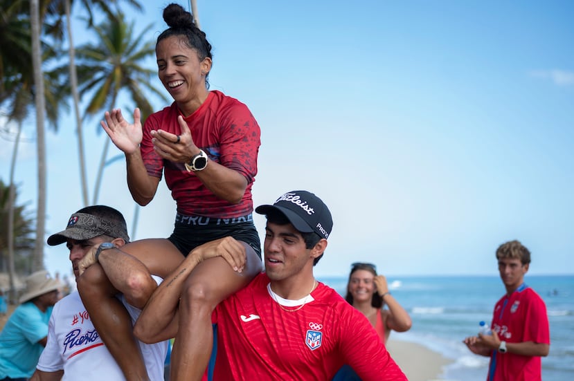 Max Torres (derecha), carga en hombros a Mariecarmen Rivera, quien conquistó el oro en la versión femenina de la prueba en que él también subió al podio.
