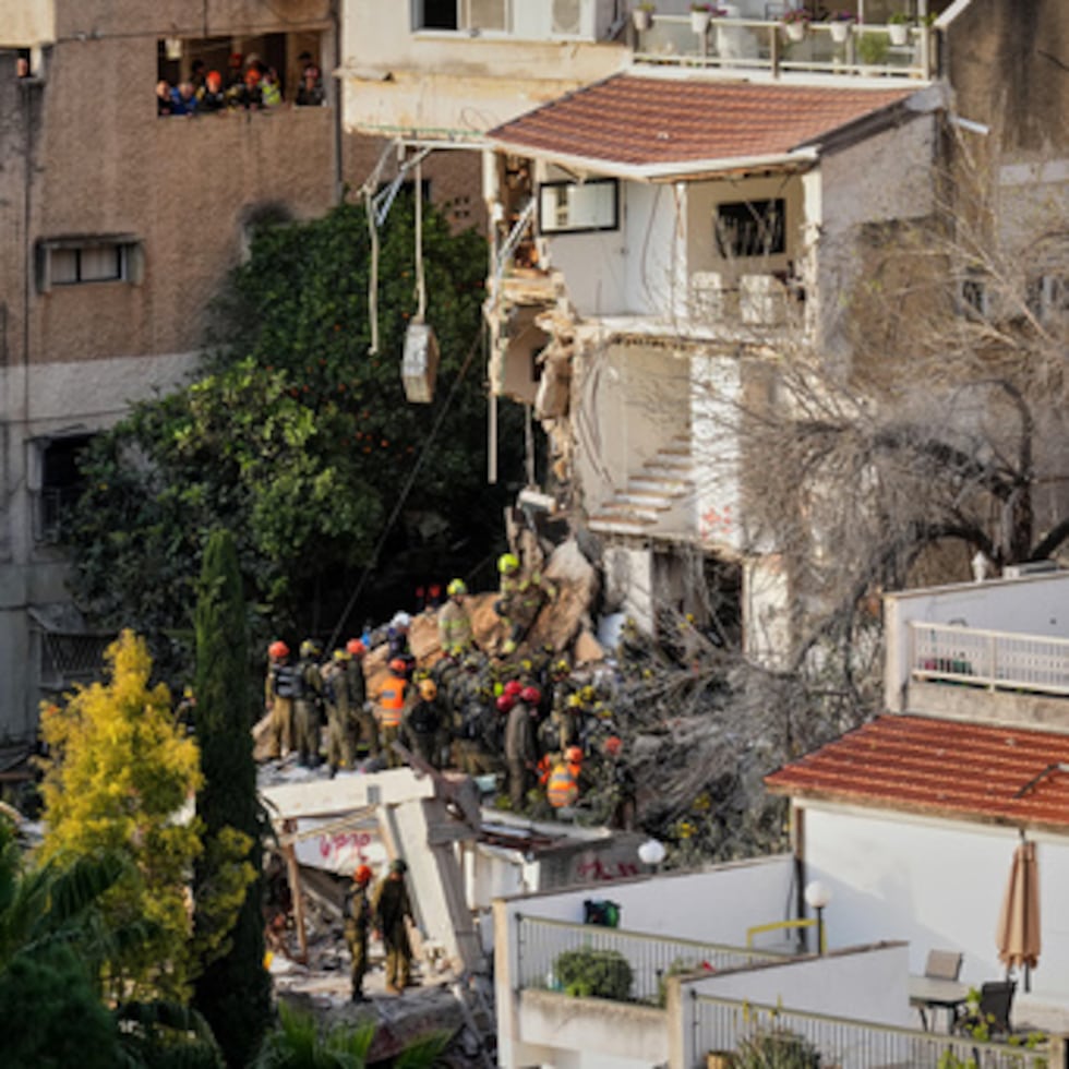 Equipos israelíes de rescate buscan el lunes desaparecidos entre los escombros de un edificio residencial alcanzado el domingo por un misil iraní en Haifa, Israel.