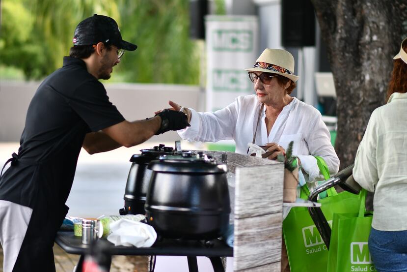 Voluntario de evento de MCS Club Te Paga sirviendo comida a participante.