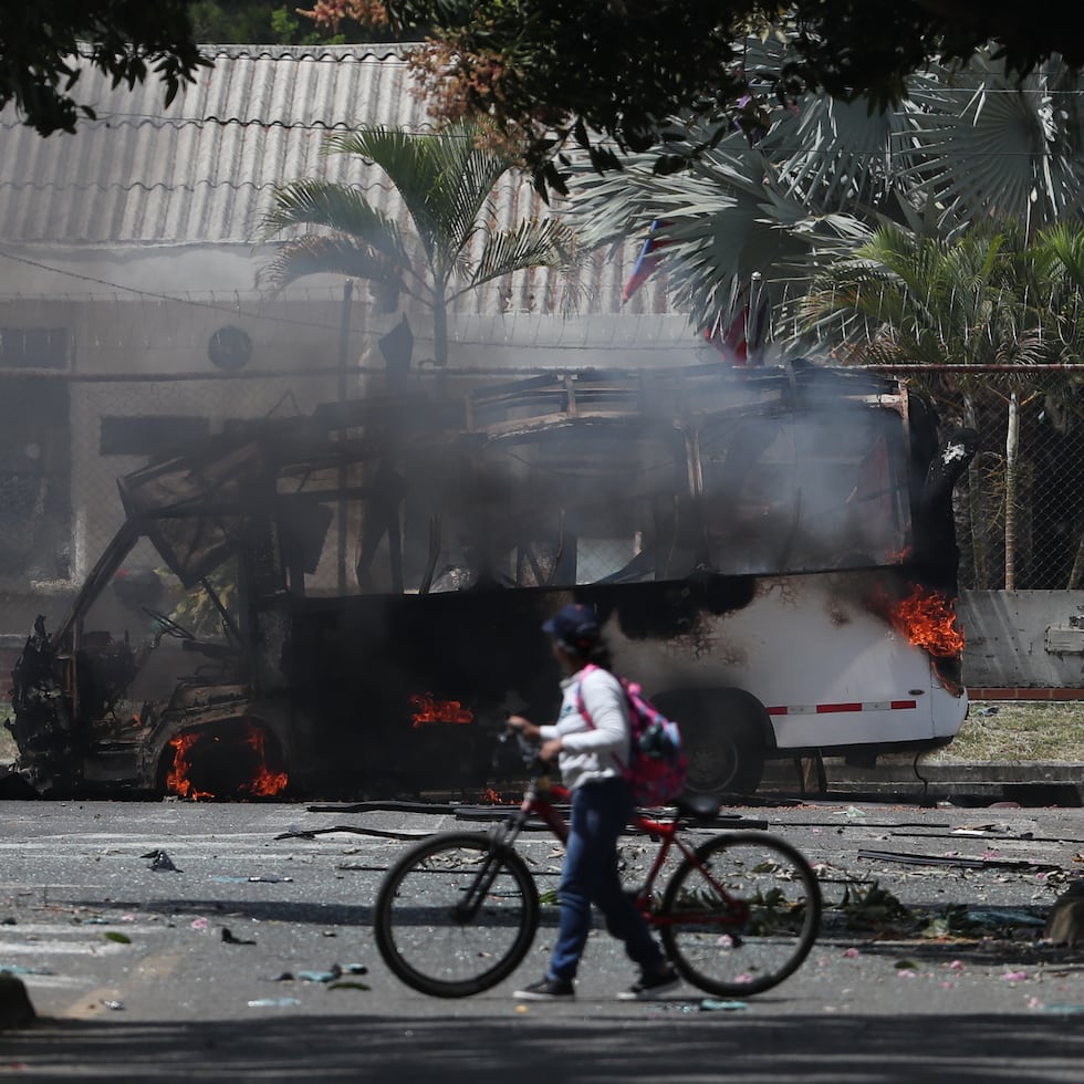 Un autobús arde tras una explosión en las afueras de una base militar en Cali, Colombia.