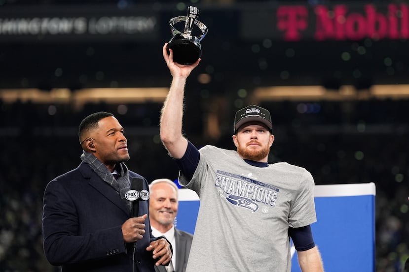 El quarterback de los Seahawks de Seattle Sam Darnold levanta el trofeo de campeón de la NFC.