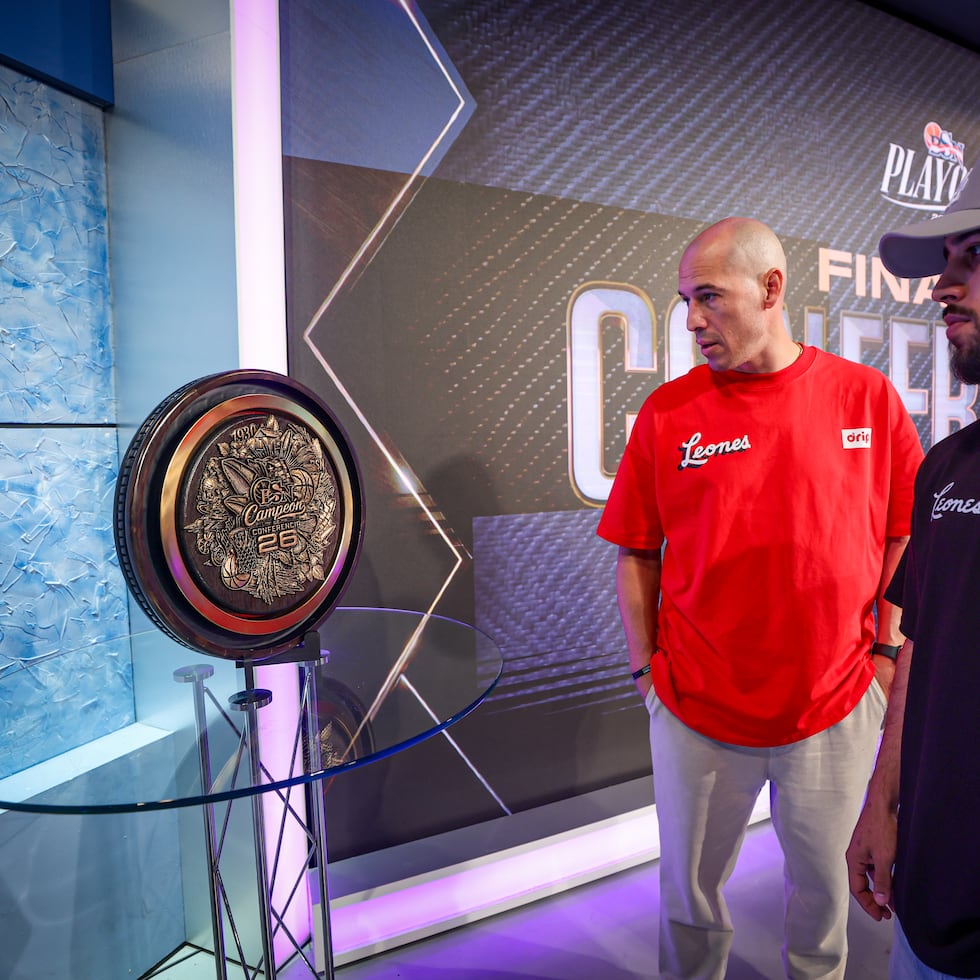 Carlos Rivera y Tjader Fernández, dirigente y jugador de los Leones de Ponce, respectivamente, observan el nuevo trofeo que se entregará a los campeones de conferencia del BSN.