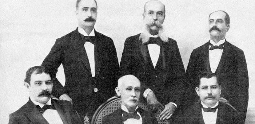 Gabinete provisional del gobierno autonómico de Puerto Rico. Sentados Luis Muñoz Rivera, Francisco Mariano Quiñonez, Manuel Fernández Juncos. De pie: Juan Hernández López, José Severo Quiñones y Manuel F. Rossy. En marzo de 1898 se llevó a cabo la elección oficial para el Gobierno Autonómico del País.