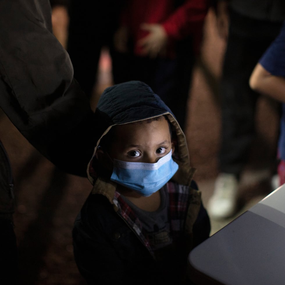 Un niño espera a responder preguntas de un agente de la Patrulla Fronteriza de Estados Unidos en un centro de acogida.