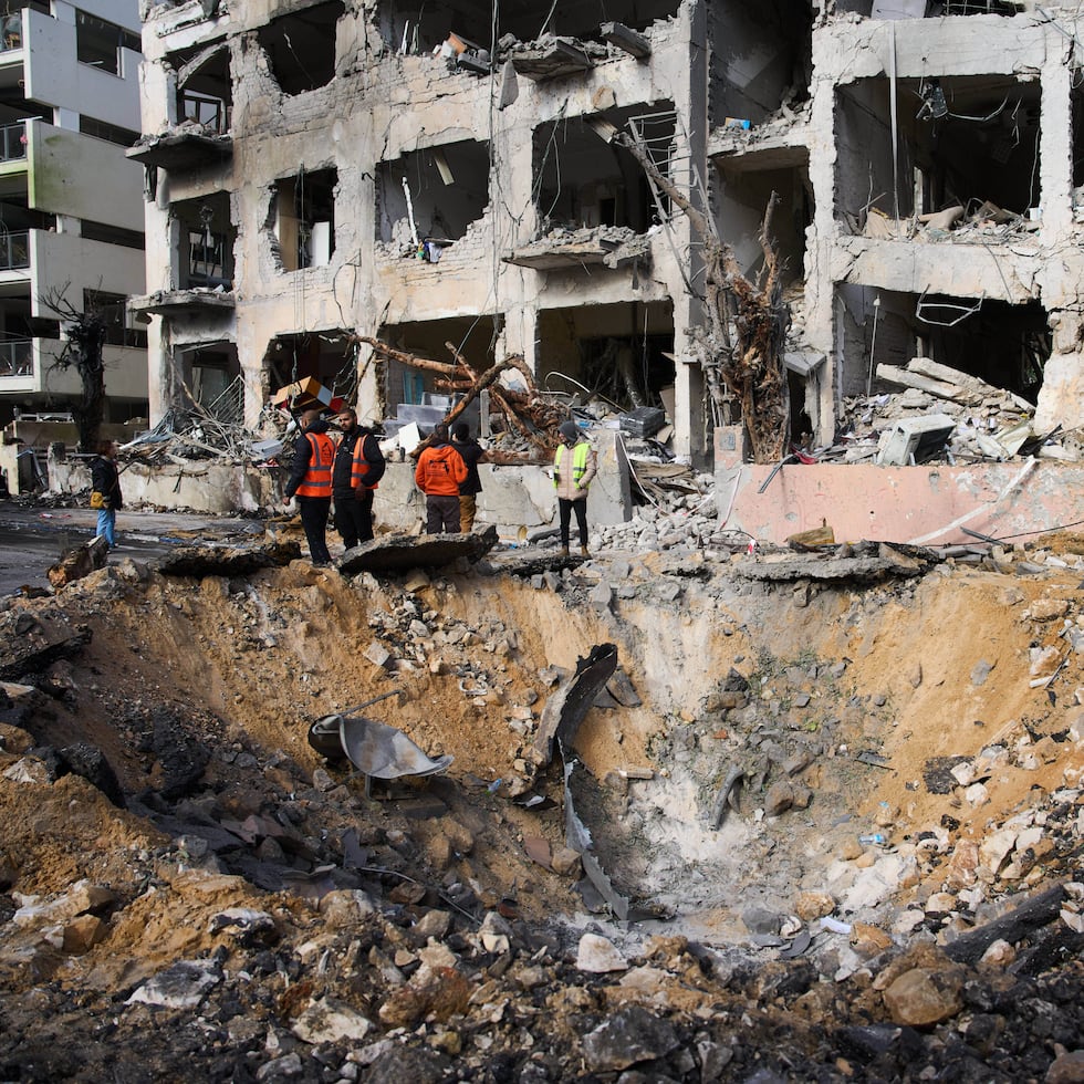 Trabajadores de rescate y personal militar observan el lugar donde impactó un misil iraní en Tel Aviv, Israel.
