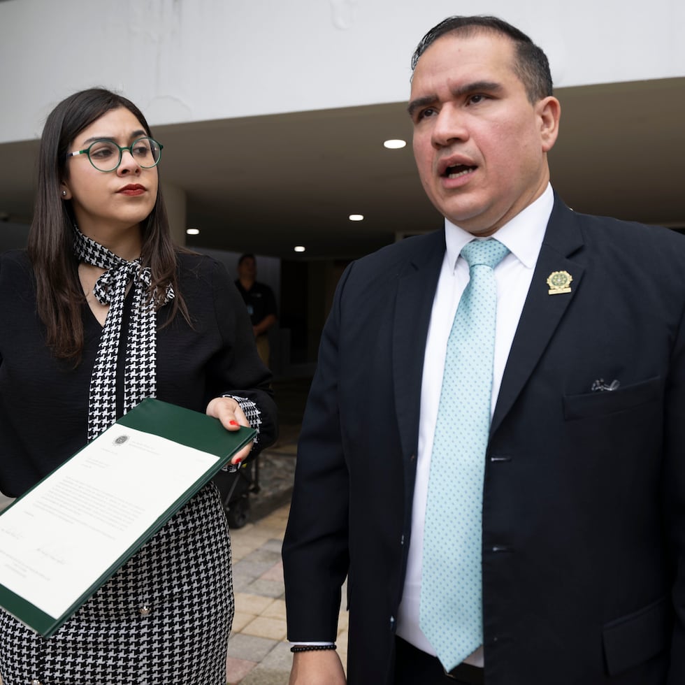 Arriba, los representantes populares Swanny Enit Vargas Laureano y Ramón Torres Cruz en la entrada de la sede del Departamento de Justicia.