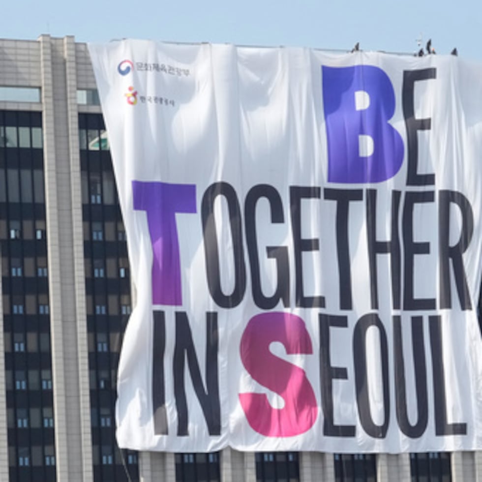 Seúl comenzó este viernes a transformarse en el epicentro del regreso de BTS. Trabajadores colocan una pancarta promocionando el concierto de regreso del grupo de K-pop BTS en el edificio del complejo gubernamental cerca de la plaza Gwanghwamun en Seúl, Corea del Sur, el viernes 20 de marzo de 2026. (AP Photo/Ahn Young-joon)