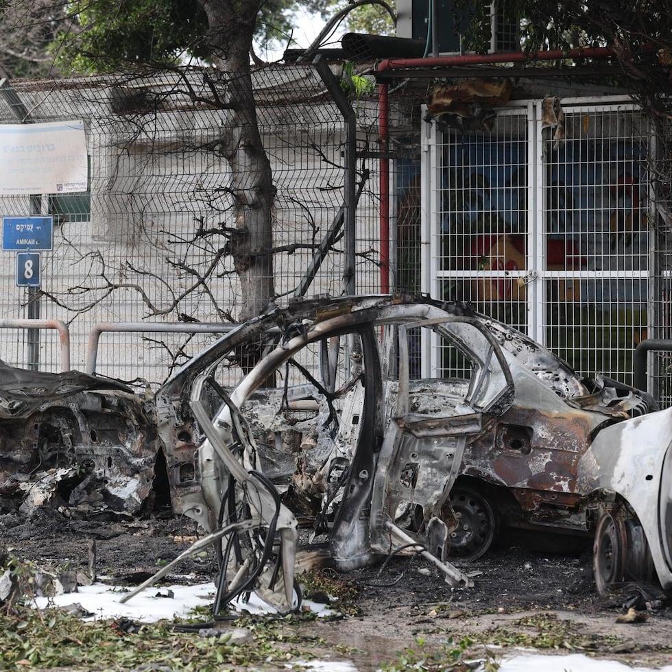Un policía israelí inspecciona coches calcinados tras el impacto de fragmentos de un misil balístico iraní interceptado en Tel Aviv, Israel.