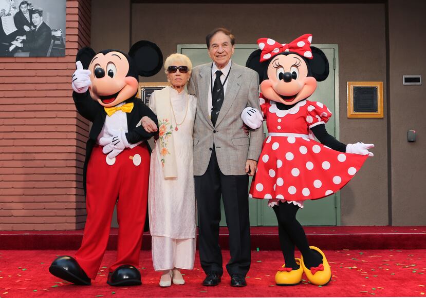 De izquierda a derecha, Mickey Mouse, Elizabeth Gluck, Richard M. Sherman y Minnie Mouse durante una ceremonia de homenaje a los hermanos Sherman en la que se renombró el Disney Studios Soundstage A durante el estreno mundial de "Christopher Robin" de Disney en Walt Disney Studios el 30 de julio de 2018.