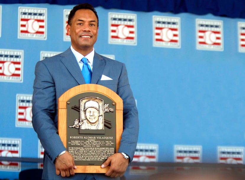 Roberto Alomar sostiene su placa del Salón de la Fama de Béisbol durante su exaltación en 2011.