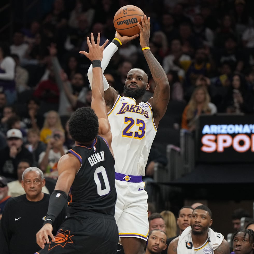 Lebron James, de los Lakers de Los Ángeles, dispara de larga distancia sobre Ryan Dunn, de los Suns de Phoenix.