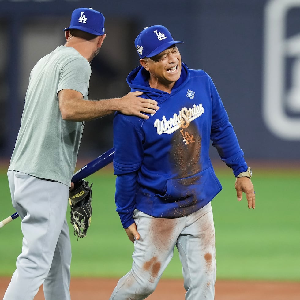 El dirigente Dave Roberts reacciona riéndose tras caerse corriendo al doblar por segunda base.
