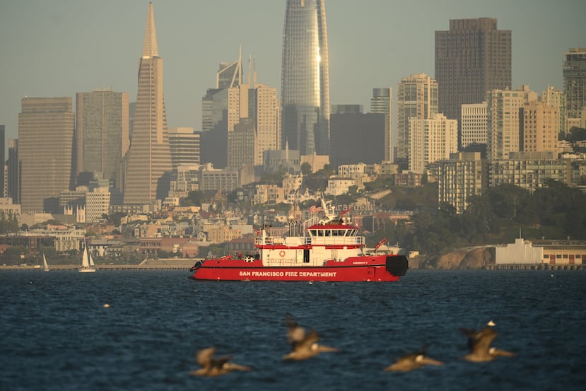 Una embarcación del Departamento de Bomberos de San Francisco sobrevuela el horizonte de la ciudad mientras busca a las víctimas desaparecidas tras un accidente náutico cerca de la isla de Alcatraz, frente a San Francisco, el martes 14 de julio de 2026. (Foto AP/Noah Berger)