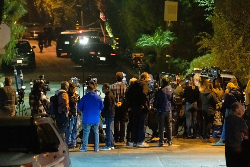 Periodistas observan a los policías que trabajan cerca de la casa de Reiner en el vecindario de Brentwood, en Los Ángeles.