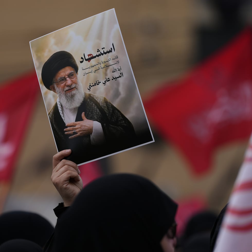 Un partidario de Hezbollah sostiene un retrato del fallecido líder supremo iraní, el ayatolá Alí Jameneí, en una marcha en un suburbio sureño de Beirut, Líbano.