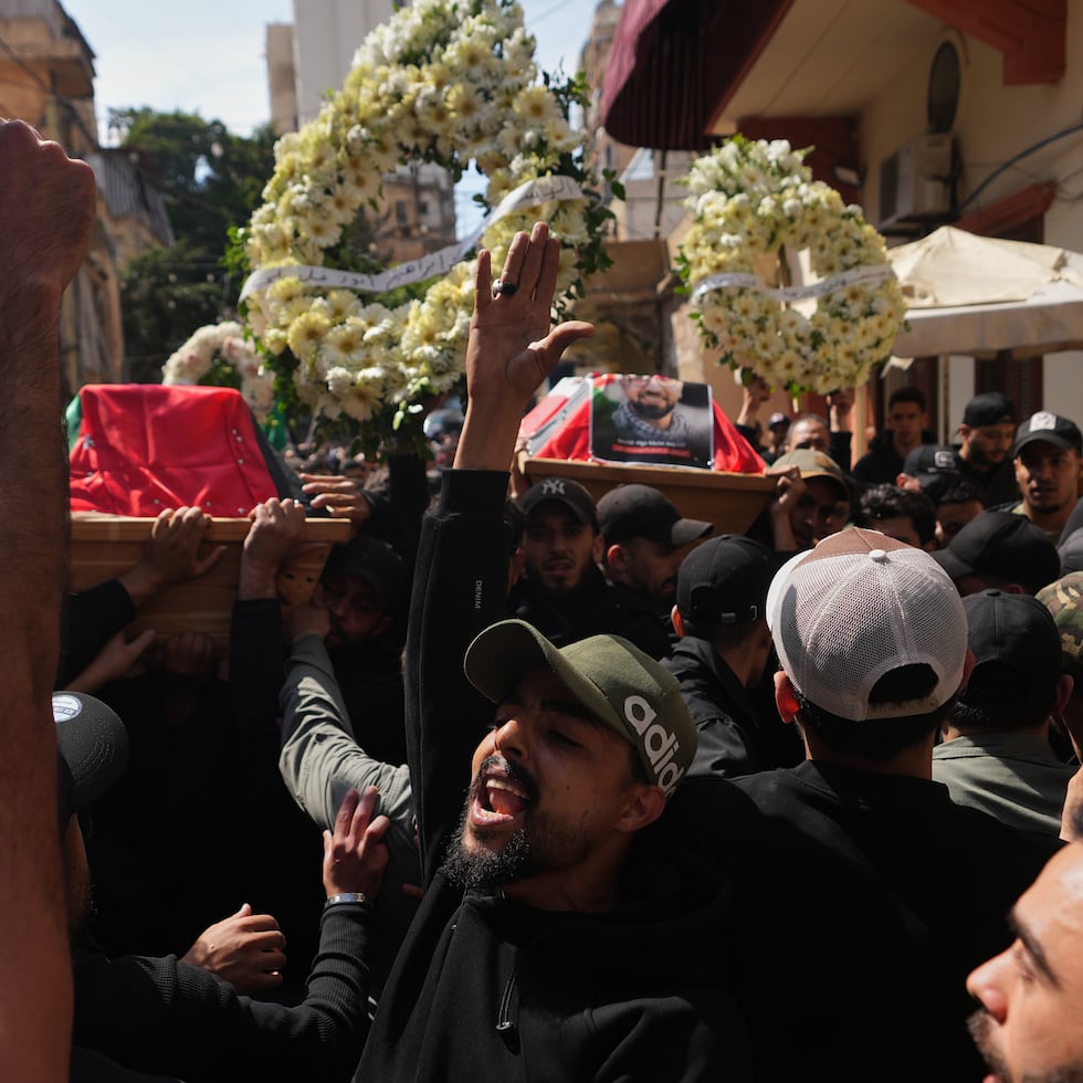 Dolientes corean consignas mientras portan los ataúdes de los combatientes palestinos Hozeifa Hamza Ghannamieh e Ibrahim Anwar al-Khalayli, quienes murieron luchando junto a Hezbollah contra Israel en el sur del Líbano, durante su cortejo fúnebre en Beirut, Líbano, el martes 28 de abril de 2026.
