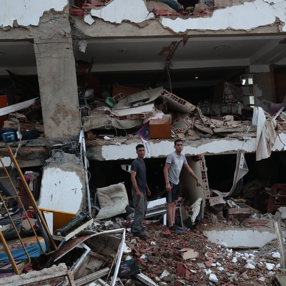 Residentes entre los escombros de uno de los bloques de viviendas dañados por los terremotos, en la localidad de Catia La Mar, en el estado costero de La Guaira (Venezuela).