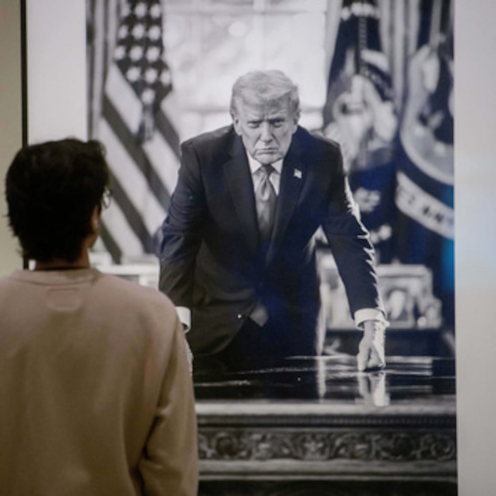 Un visitante se detiene a mirar una fotografía del presidente Donald Trump y una pequeña placa junto a ella que se exhiben en la exposición "Presidentes americanos" de la Galería Nacional de Retratos del Smithsonian.