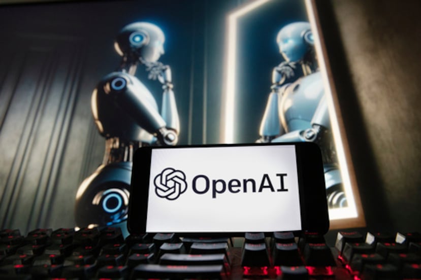 ARCHIVO - El logotipo de OpenAI se muestra en un teléfono móvil con una imagen en el monitor de un ordenador generada por el modelo de conversión de texto a imagen Dall-E de ChatGPT, el 8 de diciembre de 2023, en Boston. (AP Photo/Michael Dwyer, Archivo)