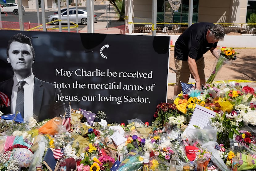 ARCHIVO - Una persona deposita flores en un altar improvisado en memoria de Charlie Kirk en la sede de Turning Point USA, el 11 de septiembre de 2025, en Phoenix. (Foto AP/Ross D. Franklin, Archivo)