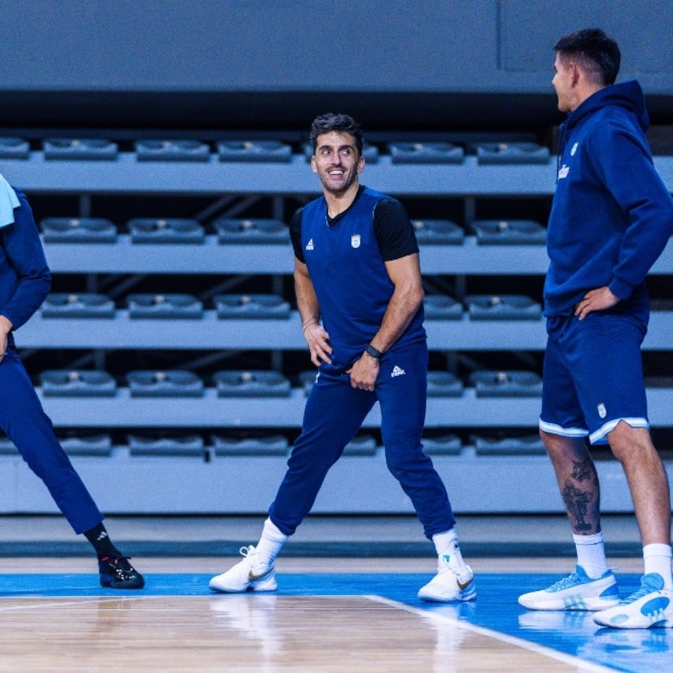 El armador Facundo Campazzo, al centro, habla con su compañero de selección y Real Madrid, Gabriel Deck.