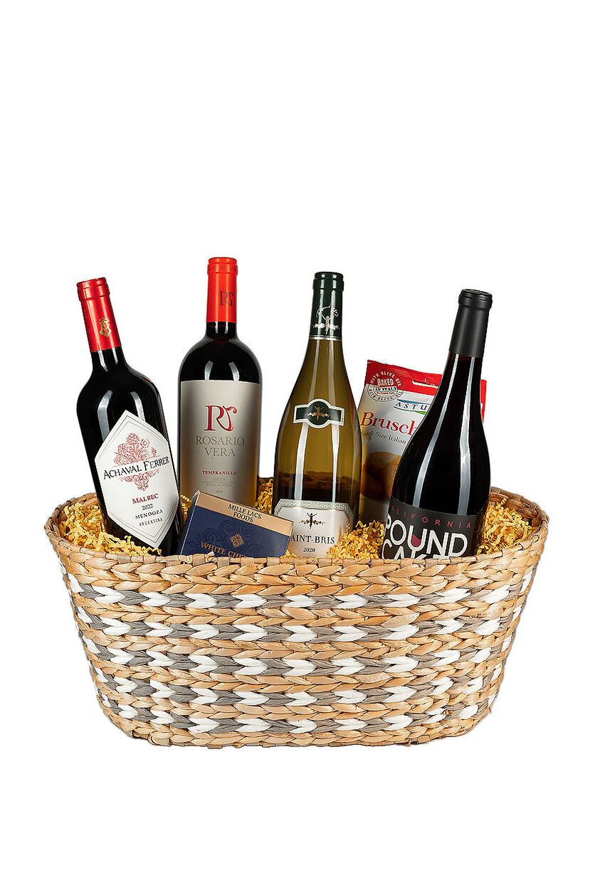 Canasta en mimbre con un surtido de vinos Pound Cake Pinot Noir, Rosario Vera, Achavar Ferrer Mendoza Malbec, Chablisienne Sauvignon Blanc y conservas.