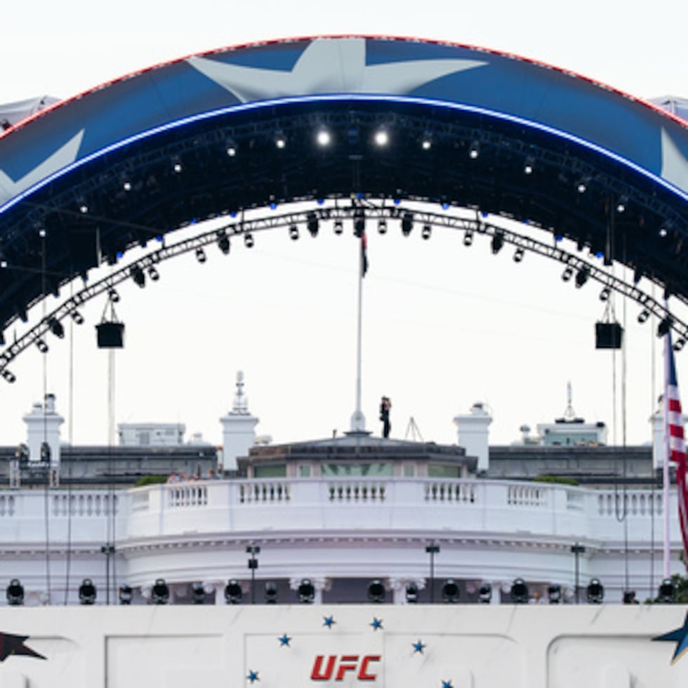 Un agente de seguridad de la Casa Blanca mira a través de unos prismáticos durante el UFC Fan Fest.