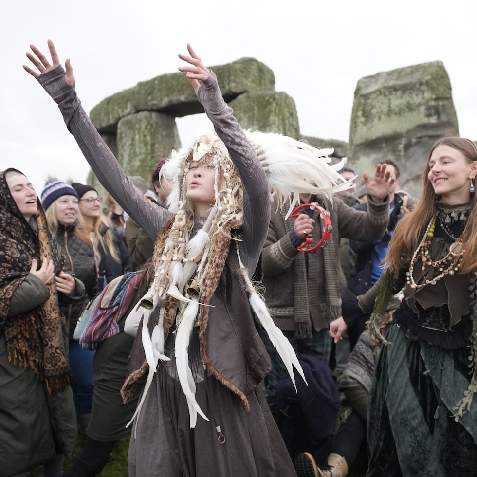 People take part in the winter solstice celebrations during sunrise at the Stonehenge prehistoric monument on Salisbury Plain in Wiltshire, England, Sunday, Dec. 21, 2025. (Andrew Matthew/PA via AP)