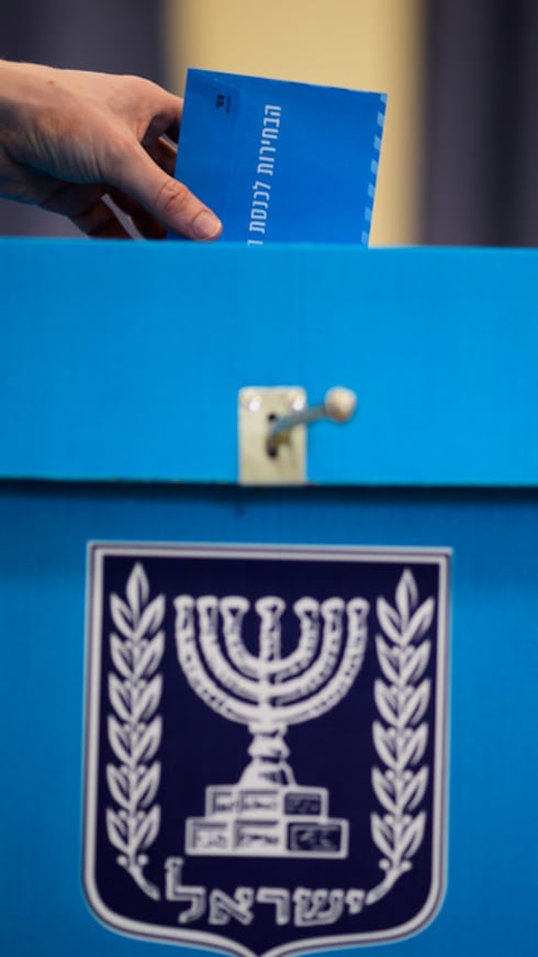 Un votante deposita su voto en una urna en Tel Aviv, Israel.