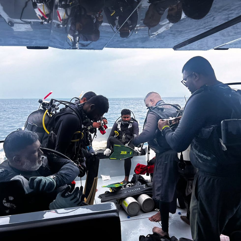 Esta imagen publicada por la oficina de medios de la presidencia de Maldivas, muestra a los buzos preparándose para buscar a cuatro buzos italianos desaparecidos cerca de la isla Alimathaa, atolón Vaavu, Maldivas.