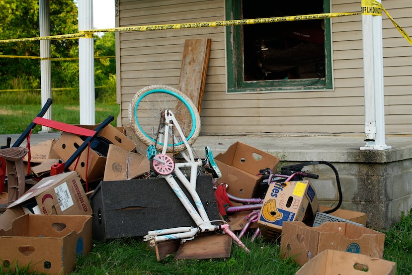 Una cinta policial rodea una vivienda y se observan escombros en el jardín delantero; las autoridades informaron que retiraron a 16 niños y detuvieron a cuatro adultos en el lugar, en Hamden, Ohio, el miércoles 1 de julio de 2026. (Foto AP/Carolyn Kaster)