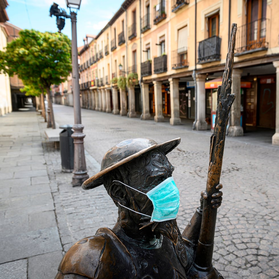 Estatua de Don Quijote con una mascarilla frente a la Casa Natal de Miguel de Cervantes en Alcalá de Henares.