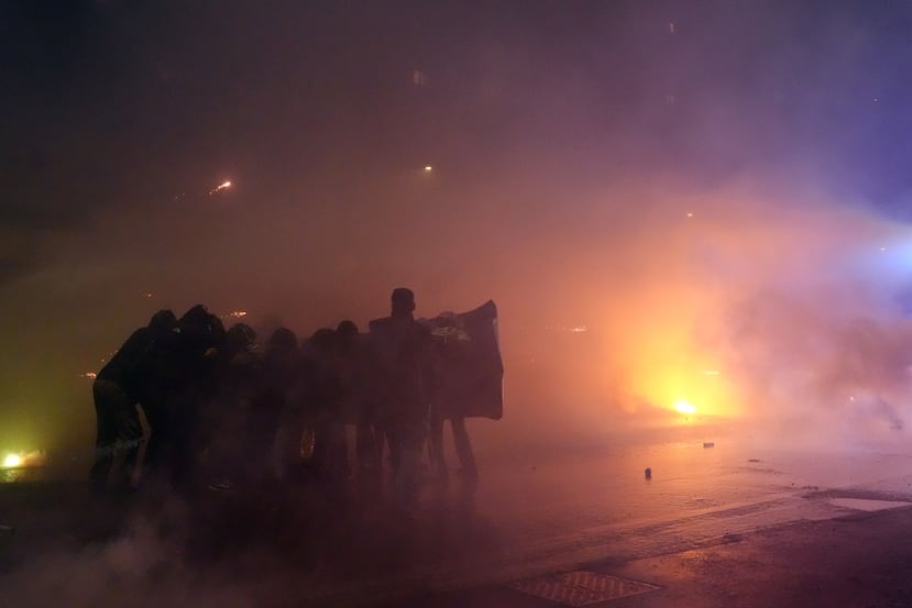 Demonstrators face the police during a protest against the Milan-Cortina 2026 Olympics, in Milan, Italy, Saturday Feb. 7, 2026. (Claudio Furlan/LaPresse via AP)