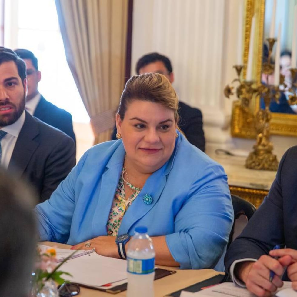 La gobernadora de Puerto Rico, Jenniffer González Colón, flanqueada, a la izquierda, por el secretario de Desarrollo Económico y Comercio (DDEC), Sebastián Negrón Reichard, y a la derecha por el secretario de la Gobernación, Francisco Domenech.