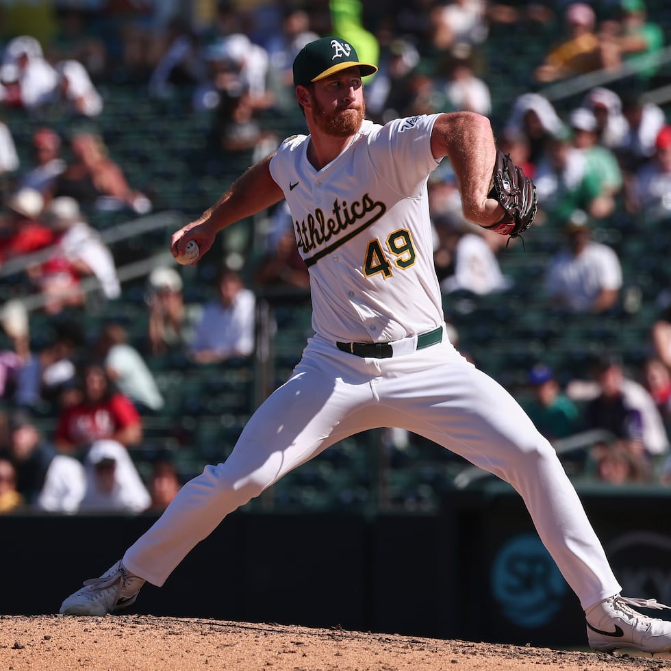 El lanzador de los Athletics, Michael Kelly, lanza contra los Reds de Cincinnati durante la novena entrada.